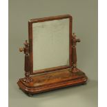 A Victorian mahogany toilet mirror, the mirror frame set between reeded and turned columns,
