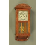 An early 20th century inlaid oak cased two train wall clock, with silvered dial.