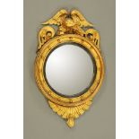 A Regency giltwood convex wall mirror, with eagle cresting, ball ornament,