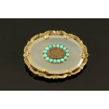 A Victorian gold coloured metal mounted chalcedony oval mourning brooch,