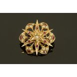 A 9 ct gold garnet and seed pearl star brooch of Victorian design by DWT.