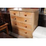 A pine 2 over 3 chest of drawers with wooden knob handles measuring 108 cm tall x 114 cm wide