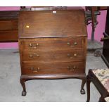 A 1920's mahogany bureau raised on claw and ball feet,