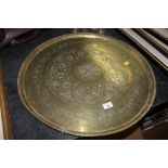 A circular brass eastern patterned tray