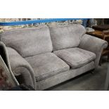 A grey fabric 2 seater settee