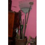 A small quantity of assorted garden tools to include rakes and pickaxes