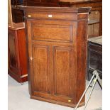 A 19th century oak corner cupboard with fielded paneled door,