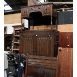 A three piece oak carved bedroom suite, comprising wardrobe, dressing table and single bed.