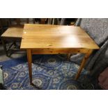 A modern pine rectangular dining table raised on tapering legs