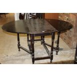 A 19th century drop leaf and gate leg table raised on baluster legs,