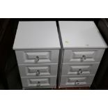 A pair of white coloured 3 drawer bedside chests with glass knob handles measuring 68 cm tall