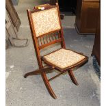 An Edwardian mahogany folding chair with floral upholstered seat and back