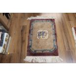 A small oriental fringed patterned rug with central horse motif and woven in purple, blue and cream,