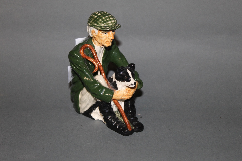 A Shebeg pottery figure of a seated shepherd and sheep dog 11.