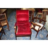 An Edwardian style desk armchair upholstered in deep buttoned red material and raised on tapering