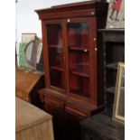 A Victorian mahogany bookcase with glazed doors opening out to two fixed shelves,