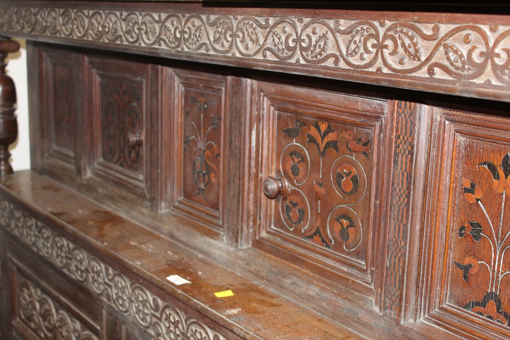 An oak carved court cupboard with inlaid doors and carved panels measuring 135 cm tall x 160 wide - Image 2 of 3