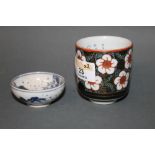 A oriental porcelain cylindrical sake cup decorated to exterior with flowers and internally with