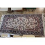 An eastern fringed patterned rug, woven in blue, red, and cream, with foliate design,