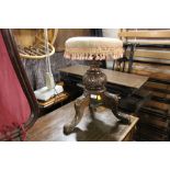 A Victorian mahogany piano stool with circular seat and carved column