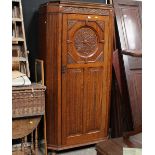 An oak carved wardrobe with linen fold door and canted angles measuring 188 cm tall