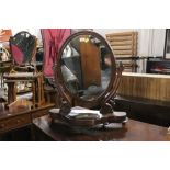 A Victorian mahogany oval shaped dressing table mirror measuring 67 cm tall