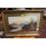 A gilt framed and mounted painting of a landscape