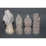 A carved soap stone figure of a standing sage and 3 similar smaller figures