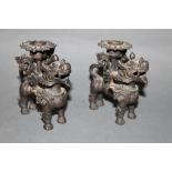 A pair of eastern bronze Dog of Fo squat candle sticks each 10 cm high