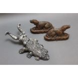 A pair of cast iron chimney ornaments, in the form of recumbent dogs.