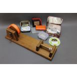 A homemade line winder, together with a tin of fly tying hooks, cast wallet,
