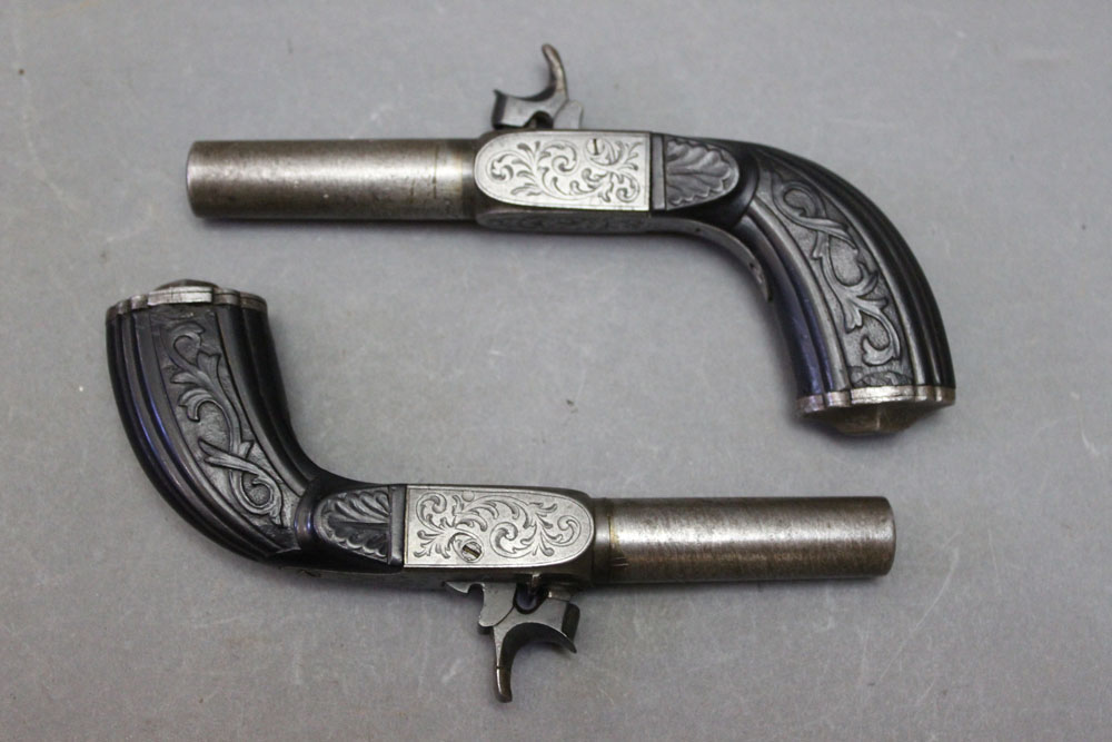 * A pair of steel percussion pocket pistols, with 2 1/2" barrels and fold down triggers,