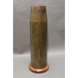 * A large brass artillery shell case, converted into a stick stand and having a turned wooden base.