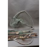 Three folding landing nets and a bow headed landing net, together with two wading sticks.