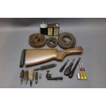 Box containing a shotgun stock, various turn screws, chamber brush handle, cleaning attachments,