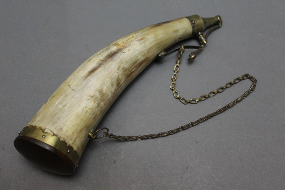 * A large powder horn with brass nozzle and hanging loop, length 31 cm.