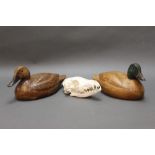 A pair of carved wooden duck decoys. 25 and 27 cm, together with a fox skull.
