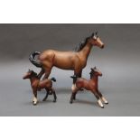 Three matt brown Beswick horses, horse with swishing tail, model No. 1182, together with two foals.