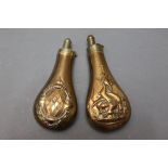 * Two copper bodied powder flasks, the first embossed with hanging game 20 cm,