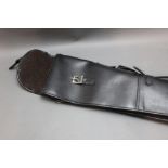 A black leather shotgun slip, with brown fleece interior. Length 130 cm.