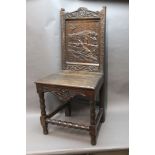 A late 19th century oak hall chair, with carved rear panel depicting man with shotgun with birds,