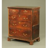 A George III oak chest of two short and three long drawers, raised on bracket feet.