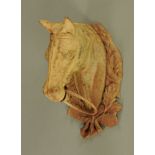 A cast iron horses head ring tie. Height 28 cm, width 18 cm.