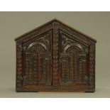 A 17th/18th century carved and panelled alms cupboard, with apex top,