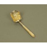 A George III silver shovel form caddy spoon, with carved mother of pearl terminal,