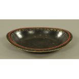 A 19th century ebonised Toleware oval bowl, with remains of gilt and red decoration, 34 cm x 26 cm.