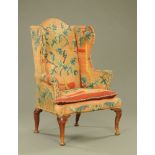 An 18th century oak wing back chair, upholstered in woven foliate tapestry with studded detail,