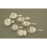 Seven George III and later silver caddy spoons, with short terminals and scalloped bowls,