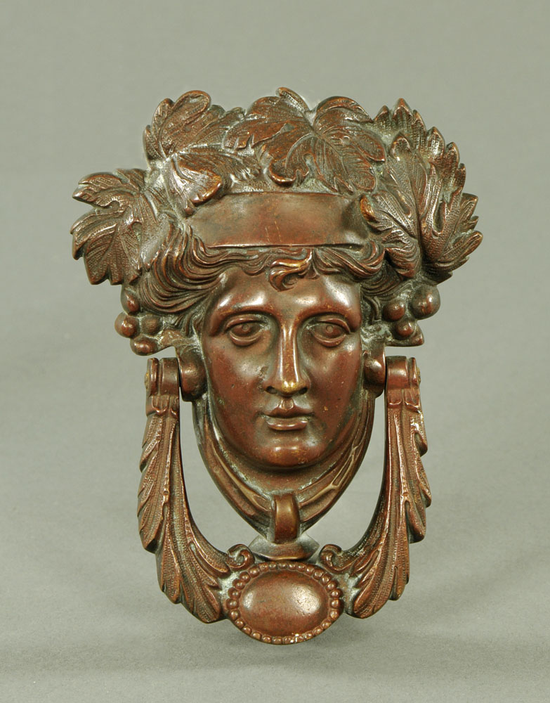 A Victorian bronze door knocker, in the form of a female face. Height 19 cm, width 14 cm.