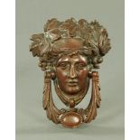 A Victorian bronze door knocker, in the form of a female face. Height 19 cm, width 14 cm.